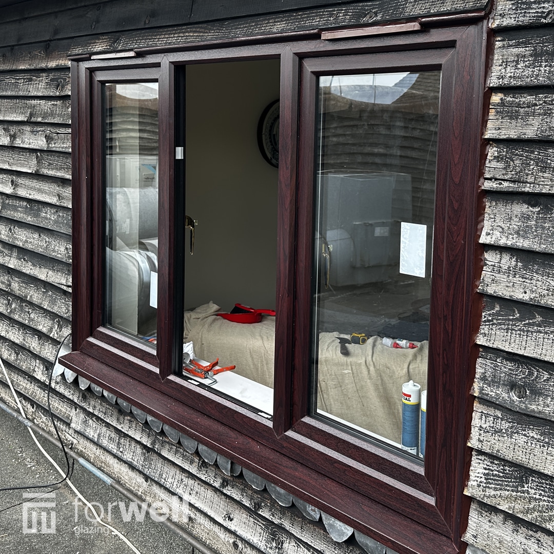New woodgrain uPVC windows fitted to a timber-clad building New woodgrain uPVC windows fitted to a timber-clad building